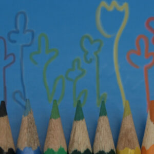 Mehrere aufgereihte Buntstifte die verschiedenfarbige Blumen auf blauem Hintergrund gemalt haben